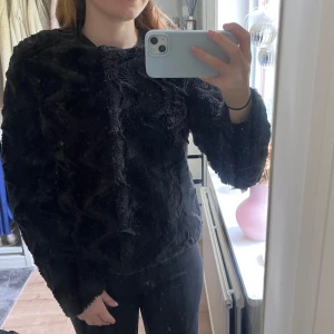Svart fusk-pälsjacka från Vero Moda - Mysig svart pälsjacka från Vero Moda. Jackan har rund halsringning och knäppning framtill med knappar. Inte använd så många gånger, och finns inga märken som tyder på användning. Säljer pga för liten för mig!