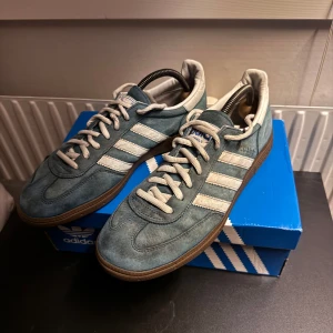 Adidas Spezial - Säljer ett par Adidas Originals Spezial i blå mocka med vita klassiska stripes och gummisula. Skorna har snörning och rund tå, samt detaljer i vitt på häl och plös. Perfekta för dig som gillar retrovibbar och streetstyle. Har tyvärr inga inner sulor