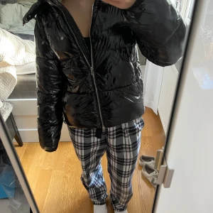 Svart pufferjacka från Nelly XS - Säljer en svart, glansig pufferjacka från Nelly i storlek XS. Jackan har dragkedja framtill, hög krage och quiltad design. Perfekt för kalla dagar och ger en cool vibe till din outfit. Finns en liten skada längst ner på dragkedjan men inget man tänker på! Pris kan diskuteras
