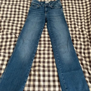 Blå bootcut jeans från 157, XXS short - Säljer ett par klassiska blå bootcut jeans från 157 i storlek XXS short. Jeansen har normal passform och snyggt utsvängda ben. Perfekta för dig som gillar en tidlös look med lite retrovibe. Materialet är jeans i bomull och de har en mellanblå tvätt.