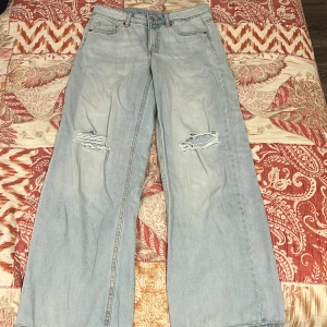 Ljusblå wide jeans från Kappahl - Ljusblå jeans från Kappahl i storlek 158 med breda ben och slitna detaljer vid knäna. Klassisk femficksmodell med låg midja och raka sömmar. Perfekta för en avslappnad och trendig look.