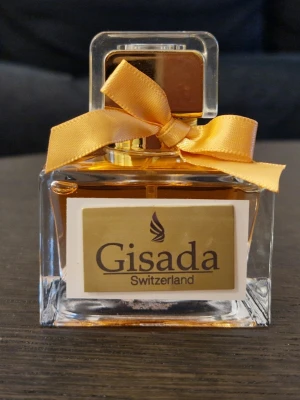 Gisada Donna EdT - Oanvänd. Köpt på Kicks för en vecka sedan. Kartongen finns tyvärr inte kvar. En pudrig söt doft. Håller lika länge som en parfym (6-8h) fast det är en EdT.   Toppnoter: Cotton candy, iris, violet, bergamot Hjärtnoter: jasmine, peach blossom, patchouli, benzoin Basnoter: musk, tuberose, sandalwood, coffee  Försöker alltid skicka 1-2 dagar efter betalning. Packar alltid väl.