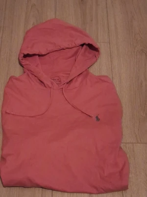 Ralph Lauren Hoodie – Trendig korallfärg - Ralph Lauren hoodie – korallfärgad Snygg och bekväm hoodie från Ralph Lauren i en fräsch korallfärg. Mycket bra skick – sparsamt använd, inga hål eller fläckar. Original med klassisk broderad Ralph Lauren-logga på bröstet. Perfekt till vardag, skola och chill – både stilren och bekväm. 📦 Snabb frakt 💬 Skriv gärna vid frågor eller om du vill ha fler bilder