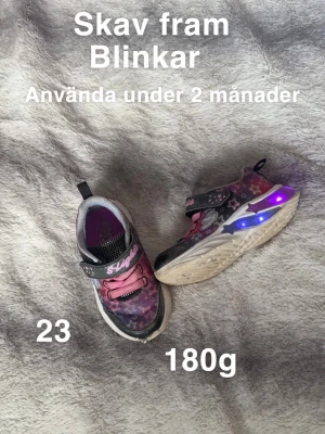 Blinkande sneakers med stjärnmönster - Färgglada sneakers från Skechers med blinkande lampor i sulan och stjärnmönster i rosa, lila och grå toner. Skorna har kardborreband med S-Lights logga och platt sula. Perfekt för dig som gillar coola detaljer och färg!🌸 Skav fram. Använd två månader. Ej tvättade. Blinkar. Storlek 23 