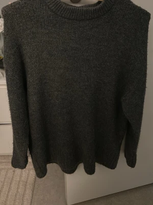 Mörkgrå stickad tröja från Amisu - Säljer en mörkgrå stickad tröja från Amisu med rund hals och långa ärmar. Har aldrig kommit till använding och är jätte skön för kyliga dagar! 