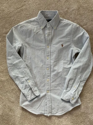 Randig skjorta från Ralph Lauren XS - Riktigt snygg skjorta från Ralph Lauren i nyskick!  ———————————————————————————                                                      📐| Storlek: XS                                                        👖| Märke: Ralph Lauren                                        🔎 | Skick: Nyskick                                                  💵 | Ny Pris: 1995 kr                                                ✍🏻 | Skriv om du har några frågor