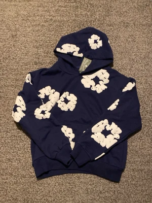 Denim tears hoodie - En mörkblå denim tears hoodie som jag bara har provat så den är i väldigt bra skick. Skriv för mer information eller bilder och kolla in shoppen för mer snygga kläder!