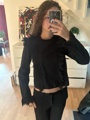 Svart blus med spets - En super fin blus med spets/broderi detaljer. Den är ifrån Hm i storlek Xxs. Perfekt till ett finare tillfälle. Knäpps även i ryggen med knappar (hela vägen)