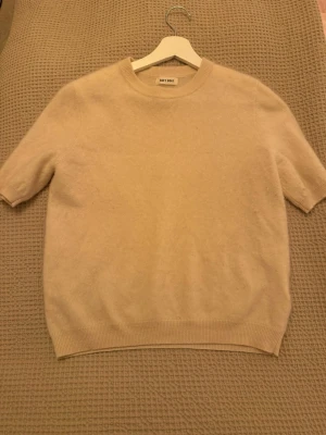 Beige kashmirtröja från Soft Goat - Superskön beige tröja från Soft Goat i mjuk kashmir med korta ärmar. I fint skick då den är använd fåtal gånger och säljs pga att den inte längre kommer till användning. Vid frågor är det bara att höra av sig🩷