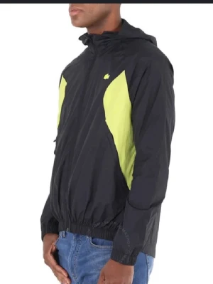 Svart och gul vindjacka från Lacoste - Säljer en svart vindjacka från Lacoste. Jackan har huva, dragkedja framtill och elastisk midja. Perfekt för dig som gillar sportig stil och vill sticka ut med färg. Materialet är lätt polyester och jackan har lång ärm. Pris kan diskuteras. Storlek är M-L