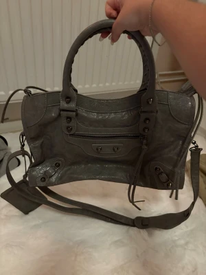 Grå stor väska  - Aldrig använd! Söt och stor väskan som får plats med allt! Du som som vill ha med mycket saker är denna perfekt! Plus har en lite en spegel som kommer med väskan 