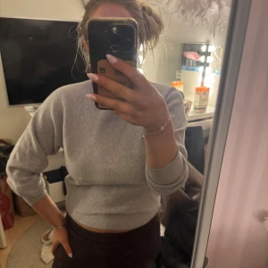 Grå stickad tröja från Vero Moda - Säljer en enkel och stilren grå tröja från Vero Moda i croppad modell. Tröjan har rund hals, ribbade muddar och lång ärm. Knappt använd skriv vid frågor!🤍