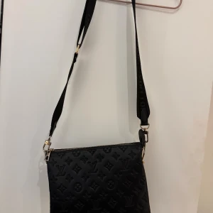 Svart cross body väska  - Jätte fin väska med monogram och logo rem. Lite sliten på guldet