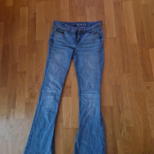 Blå lowwaist bootcut jeans från Denim - Säljer ett par klassiska ljus blå bootcut jeans från Denim. De är tillverkade i jeansmaterial och har en snygg utsvängd passform nertill. Perfekta för dig som gillar retrovibbar och avslappnad stil. De är lågmidjade se bild 3. Inga defekter eller problem med dem, för små för mig