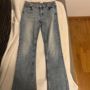 Ljusblå bootcut jeans Gina Tricot - Ljusblå jeans från Gina Tricot i klassisk bootcut-modell. Jeansen har fem fickor, normal passform och är tillverkade i denim med lätt tvättad look. Perfekta för en avslappnad och trendig stil.