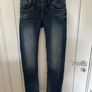 Blå slim straight jeans från LTB - Snygga blå jeans från LTB med slim straight passform och låg midja. Materialet är mjukt och följsamt jeans.