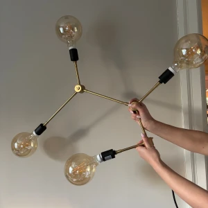 Franklin Chandelier Tribeca - Elegant Franklin Chandelier i mässing från Audo Copenhagen, Tribeca-serien. Fyra armar med stora LED-glödlampor, modern design. Små tecken på användning, men i gott skick. Perfekt för stilfull belysning i hemmet. Säljs komplett med glödlampor., en ljustjälla sönder