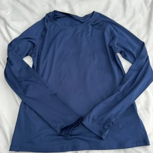 Långärmad träningströja  - Mörkblå träningströja med rund halsringning & tumhål för extra komfort. Aldrig använd. Fraktar inom 24h!