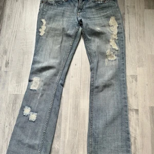 Ljusblå slitna bootcut jeans - Snygga bootcut jeans! Midjetmått: 42cm tvärsöver, innerbenslängd 74cm