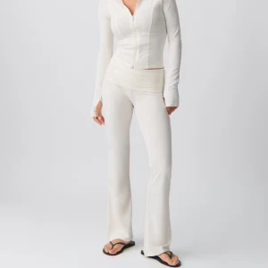 Vita yogapants🤍 - Snygga vita bootcut-byxor med ribbad struktur och låg midja. Byxorna har en mjuk och stretchig passform som sitter skönt och följer kroppen. 