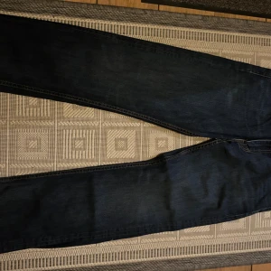Levi's 504 mörkblå jeans W33 L32 - Mörkblå Levi's 504 jeans med klassisk femficksdesign och raka ben. Jeansen har snygga kontrastsömmar och är tillverkade i slitstarkt denim. Perfekta för dig som gillar en tidlös och stilren look.