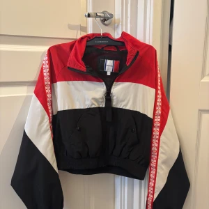 Röd, vit och svart vindjacka Jennyfer XS - Snygg croppad vindjacka färgerna röd, vit och svart. Köpt från Paris och använt ett fåtal gånger. Fler bilder finns🥰
