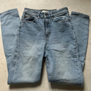 Ljusblå jeans från H&M - Ljusblå jeans från H&M med raka ben. Jeansen har hög midja och är tillverkade i bomull med en snygg tvättad look. Perfekta för en avslappnad stil och passar till det mesta.