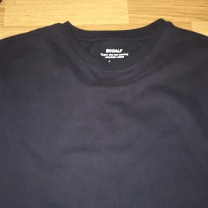 Svart långärmad tröja från Ecoalf - Säljer en svart långärmad tröja från Ecoalf med rund hals och en diskret etikett på ärmen. Tröjan är tillverkad i mjuk bomull och har en clean, enkel design som funkar till många olika stilar. Perfekt för dig som gillar minimalistiskt och hållbart mode.