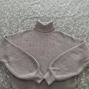 Grå stickad polotröja från NA-KD - Säljer en chunky grå polotröja från NA-KD med bred ribbstickning och oversized ärmar. Tröjan har hög krage och är perfekt för lager-på-lager. Supermjuk och skön att bära under kyliga dagar.