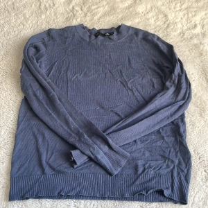 Blå stickad tröja från 157, stl M - En stilren blå stickad tröja från 157 i storlek M. Tröjan har rund halsringning, långa ärmar och ribbade muddar vid ärmslut och nederkant. Perfekt för lager-på-lager och enkel att matcha med jeans eller kjol.