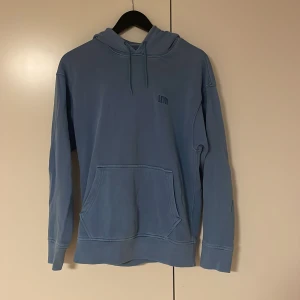 Blå hoodie från Levi's med huva - Säljer en blå hoodie från Levi's i relaxed fit. Tröjan har en stor huva med snörning, magficka och broderad Levi's-logga på bröstet.  Materialet är mjuk bomull och modellen är långärmad.                      Måttligt använd.