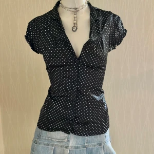 Svart prickig blus med knappar - Coquette shirt the first button is missing will fit s/xs  Kolla gärna på mina andra mina andra annonser 
