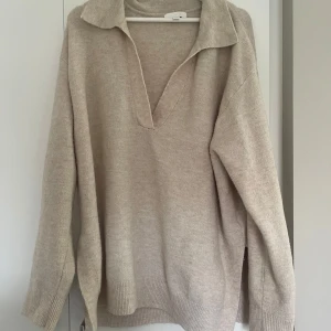 Beige stickad tröja med krage H&M - Säljer en beige stickad tröja från H&M i storlek M. Tröjan har en bred krage, v-ringning och långa ärmar. Den är loose fit och har slits på sidorna💗💗💗