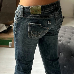 Lågmidjade Blå bootcut jeans  - Snygga blå jeans från Success med bootcut passform och låg midja. Jeansen har slitna detaljer. 