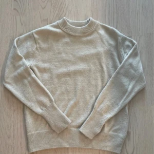Cremevit stickad tröja - Cremevit stickad tröja ifrån H&M, den har små slits vid ärmmuddarna.