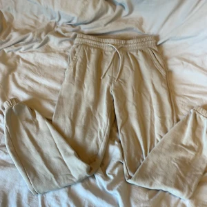 Beige mjukisbyxor från H&M Divided XS - Beiga mjukisbyxor från H&M Divided i storlek XS. Byxorna har resår och snörning i midjan, sidofickor och är gjorda i en mjuk bomullsblandning. Perfekta för chill dagar eller när du vill vara extra bekväm.