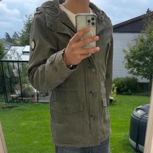 Olivgrön parkajacka från Replay - | Säljer denhär stiliga jackan från Replay | Den är fodrad på insidan och perfekt nu till vintern och kallare dagar | Osäker på storlek men skulle gissa L den sitter väldigt bra på mig som är 187 | Skick 9/10 bara på insidan lappen som märks att den är använd | Pris 299 kan diskuteras |