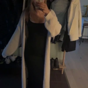 Svart långklänning med smala axelband - Stickad cremefärgad kofta. Jag är 160 cm.