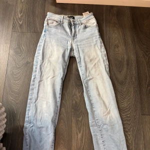Ljusblå straight jeans  - Säljer ett par ljusblå jeans från Vero Moda i klassisk straight modell. Jeansen har fem fickor, normal passform och är tillverkade i bomull med en snygg tvättad look. Perfekta för dig som gillar en enkel och stilren vibe. Använda ett fåtal gånger. 