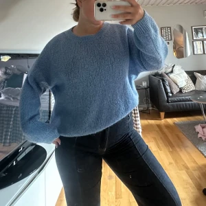 Ljusblå stickad tröja - Mysig ljusblå stickad tröja med rund hals och lång ärm. Tröjan har en loose passform och är perfekt att slänga på sig när det är kyligt ute. Enkel och stilren design som passar till jeans eller kjol. Passar xs-M