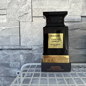Tom Ford Tobacco Vanille Eau de Parfum 100 ml - Säljer en lyxig Tom Ford Tobacco Vanille Eau de Parfum i en elegant svart flaska med guldiga detaljer. Flaskan rymmer 100 ml och har en stilren design som passar perfekt på parfymhyllan. En doft som kombinerar rika tobaksnoter med söt vanilj för en sofistikerad och varm upplevelse.