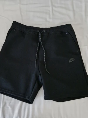 Nike tech shorts - Ett par svarta nike tech shorts, bara använda några gånger, det står xl på storlekslappen men de passar m och s, det finns mått på bild 4 och 5