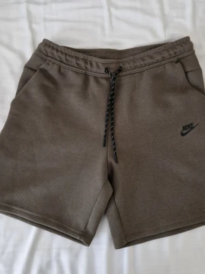 Nike tech shorts  - Ett par gröna nike tech shorts, bara använda några gånger, det står xl på storlekslappen men de passar m och s, det finns mått på bild 4 och 5