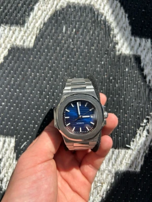 Seiko nautilus mod - Custom Nautilus klocka 40mm som består av ett automatiskt NH35 urverk från seiko med 41 timmar reserv.                                               En robust och solid klocka med hög kvalité!                                              Datumvisare, självlysande visare, safir glas både fram och bak där man ser urverket jobba.