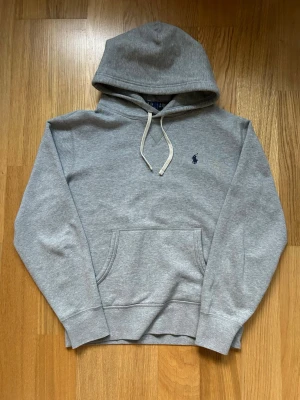 Grå hoodie från Polo Ralph Lauren - Säljer nu denna gråa hoodien från Ralph Lauren i storlek S. Skriv vid frågor  Bredd 48cm Längd 60cm  Armlängd 55cm