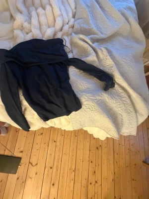 Mörkblå långärmad tröja Gina Tricot - En enkel och stilren mörkblå of shoulder tröja från Gina Tricot. Tröjan har en rak passform och är tillverkad i ett mjukt material som passar perfekt till vardags. Snygg att matcha med jeans eller kjol.