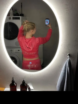 Rosa Juicy Couture velourset - Säljer ett ikoniskt rosa velourset från Juicy Couture med strassdetaljer och texten 'Juicy' på både byxorna och hoodien. Setet består av en zip-hoodie med huva och matchande byxor med resår i midjan. Perfekt för dig som gillar Y2K-stil och vill ha något riktigt bekvämt. Pris går alltid att diskutera 💞Nypris för hela setet ligger på ca 2200 och jag har inte använt det mycket alls! 
