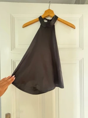 Svart halterneck topp i satin - Säljer min svarta satin tröja som är öppen i ryggen. Jag fick den av min kompis men skulle gissa på att tröjan kommer från shein, därför sätter jag lågt pris som går att förhandla ner. 