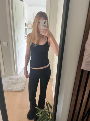 Svarta bootcut leggings - Säljer ett par svarta leggings med bootcut-modell. De har hög midja och sitter tight över låren men är utsvängda nedtill. Materialet ser stretchigt och mjukt ut, perfekt för en avslappnad och trendig look. jag har råkat klippa av lappen där det står storleken men jag skulle hi gissa på att det är den storlek mellan XXS och XS