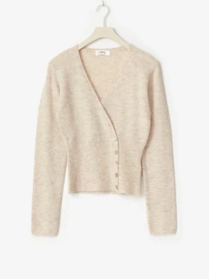 Beige omlottkofta - Snygg beige omlottkofta med v-ringning och dekorativa knappar i sidan. Koftan har lång ärm och är stickad i ett mjukt, fluffigt material som ger en mysig känsla. Perfekt att styla med jeans eller kjol för en trendig look.